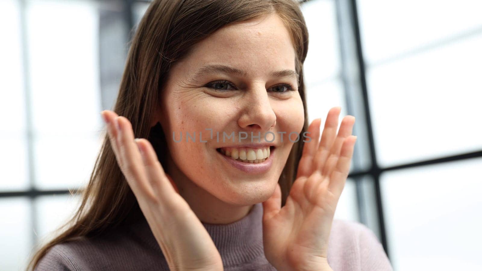 A woman's face is in close-up in the office, she looks at the screen and is surprised.
