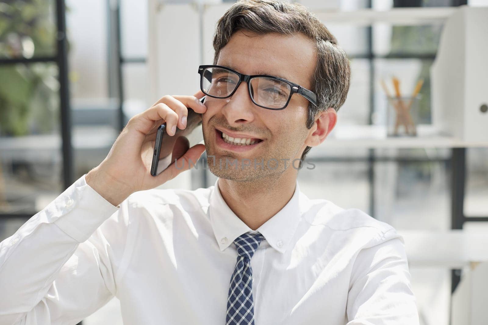 Man accountant or business lawyer talking on smartphone with finance paperwork at workplace