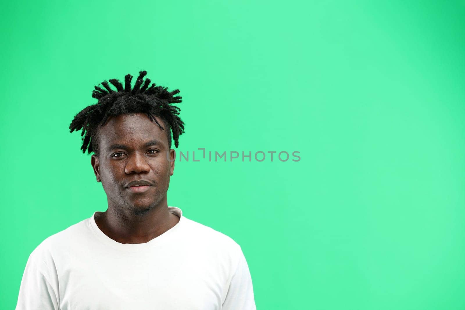 A man, close-up, on a green background.