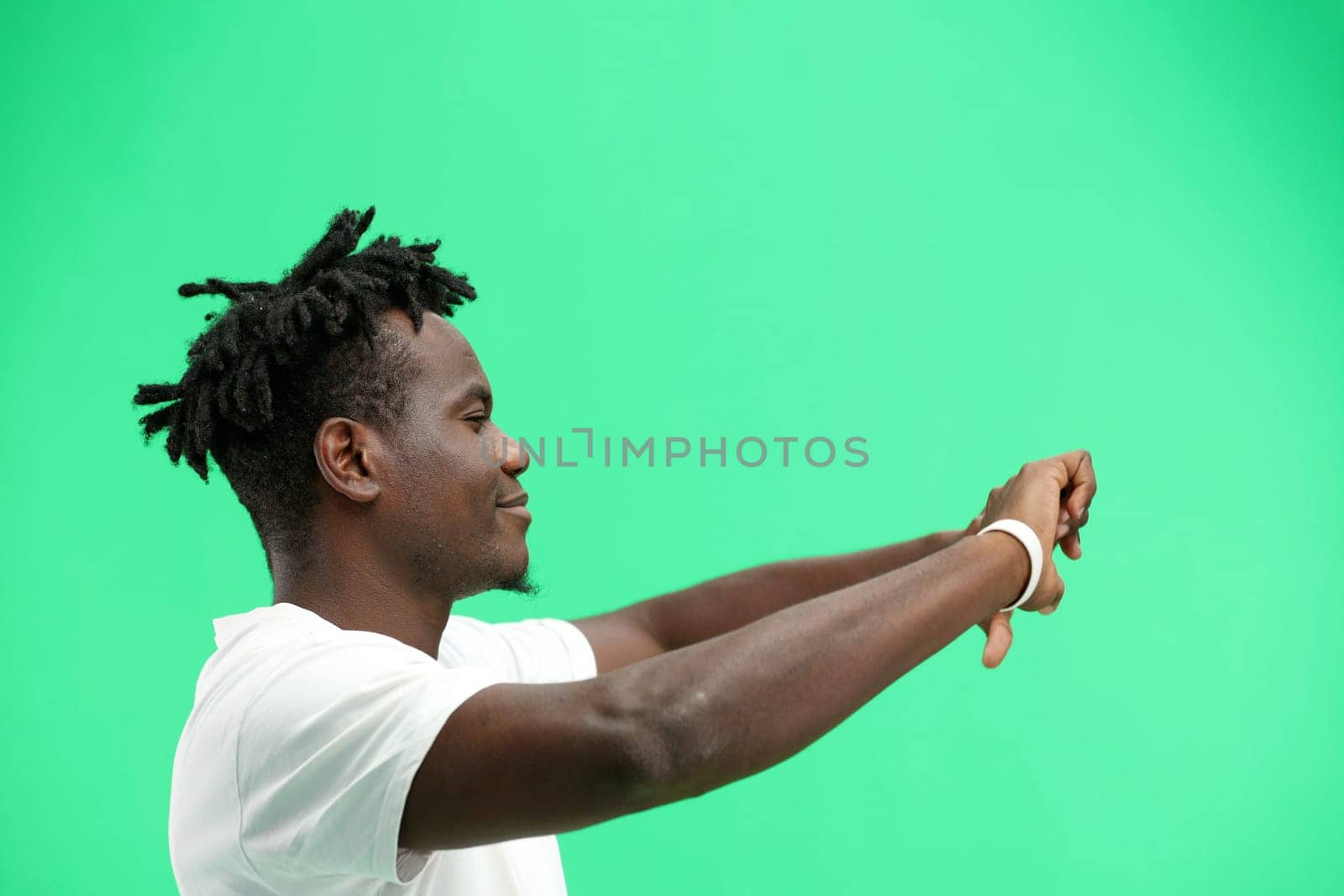 A man, close-up, on a green background, shows his thumbs down.