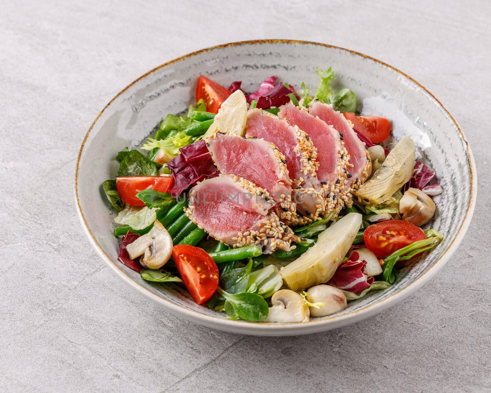 Tuna and artichoke salad on a stone background studio food photo