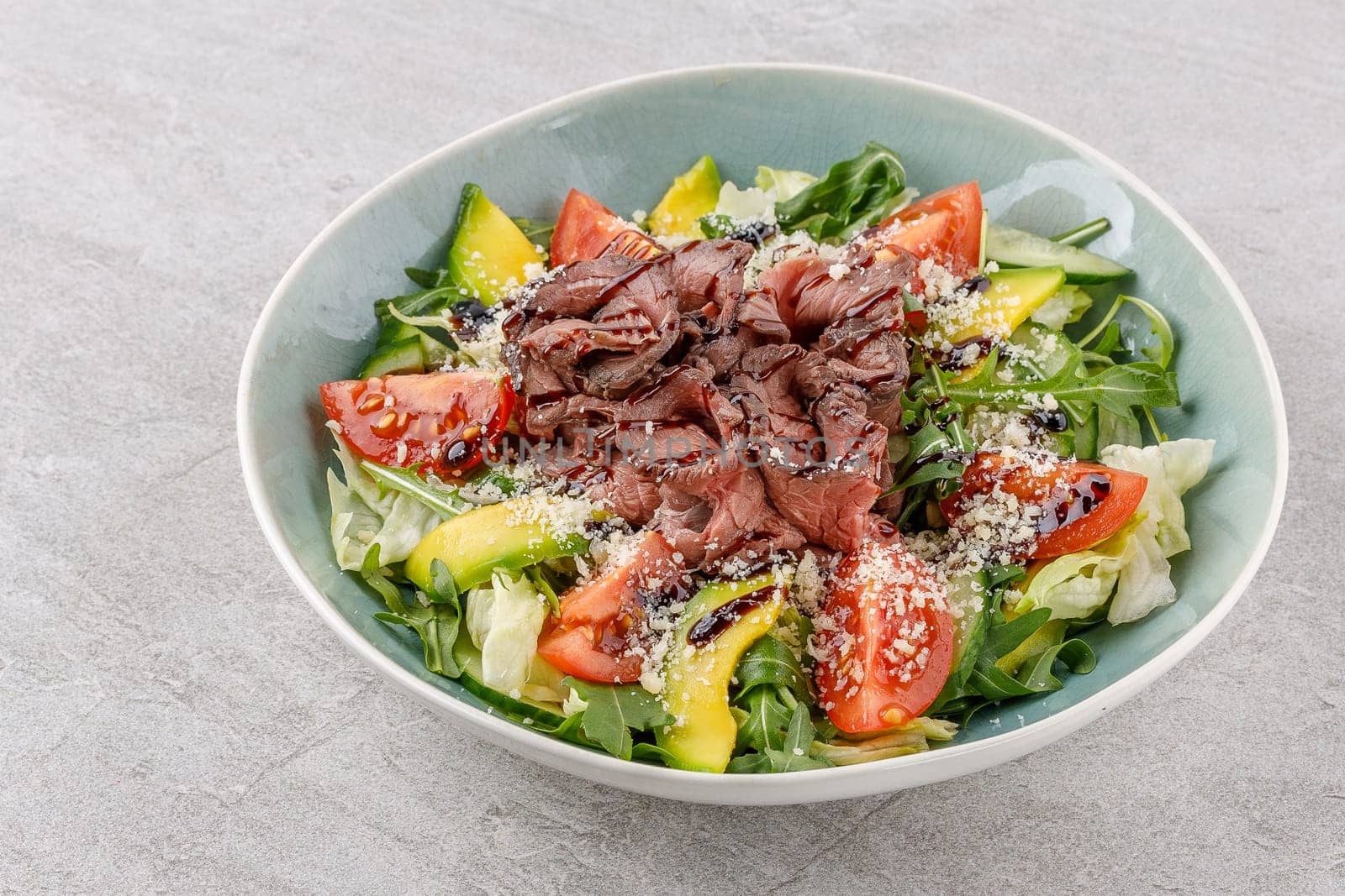 Salad with roast beef, avocado and tomatoes on a stone background studio food photo 1