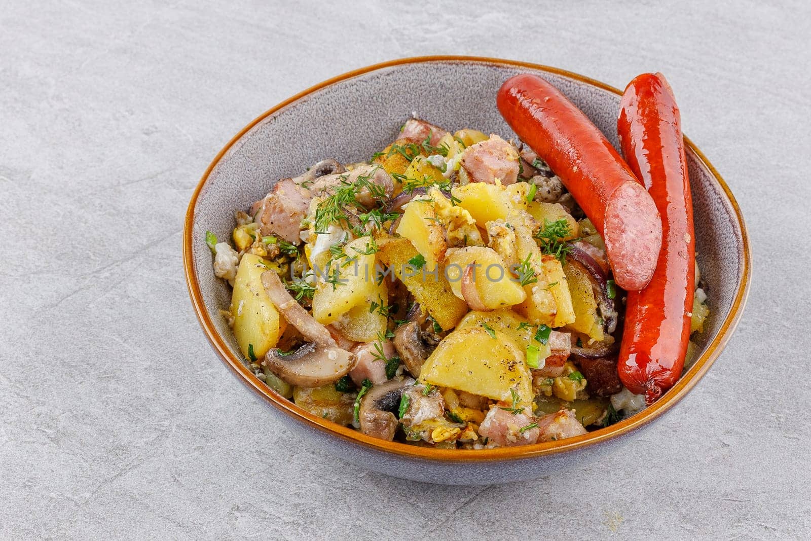 fried potatoes with mushrooms and sausages on a stone background studio food photo 3