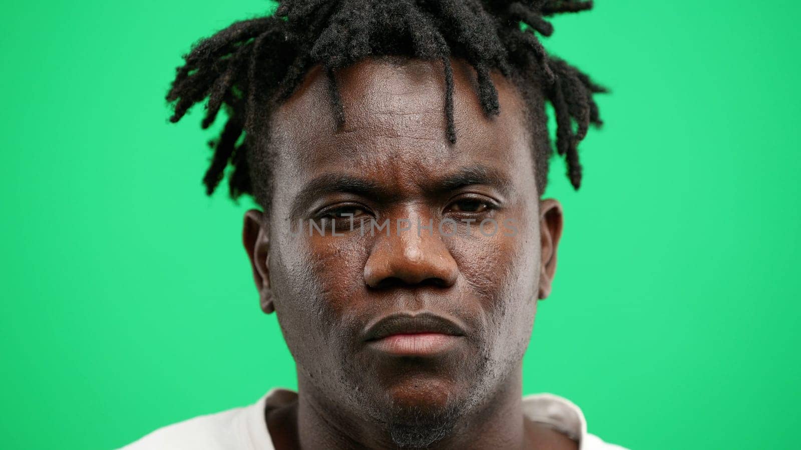 Man's face, close-up, on a green background.