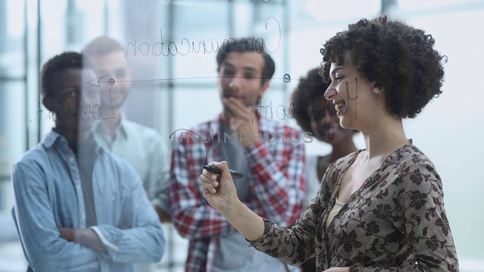 a team of young designers sticking notes on glass in a modern office by Prosto