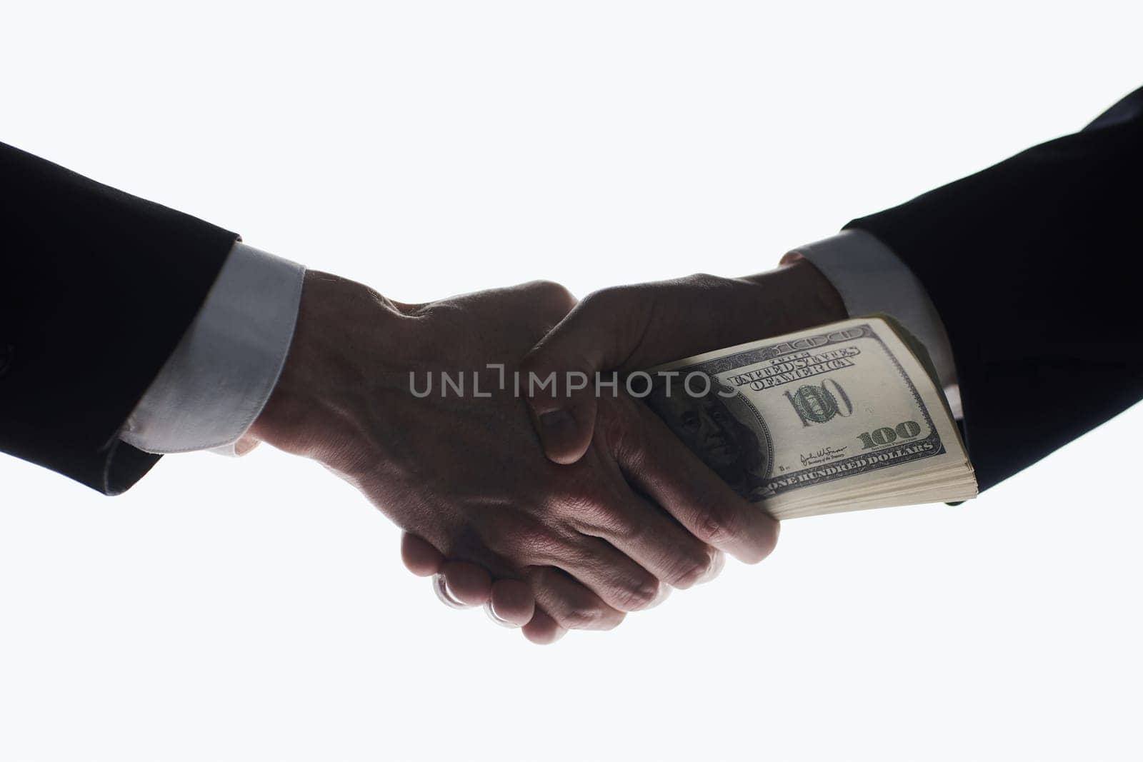 Businessmen's handshake and money transfer. Simple and effective approach. Be attentive with your partners.