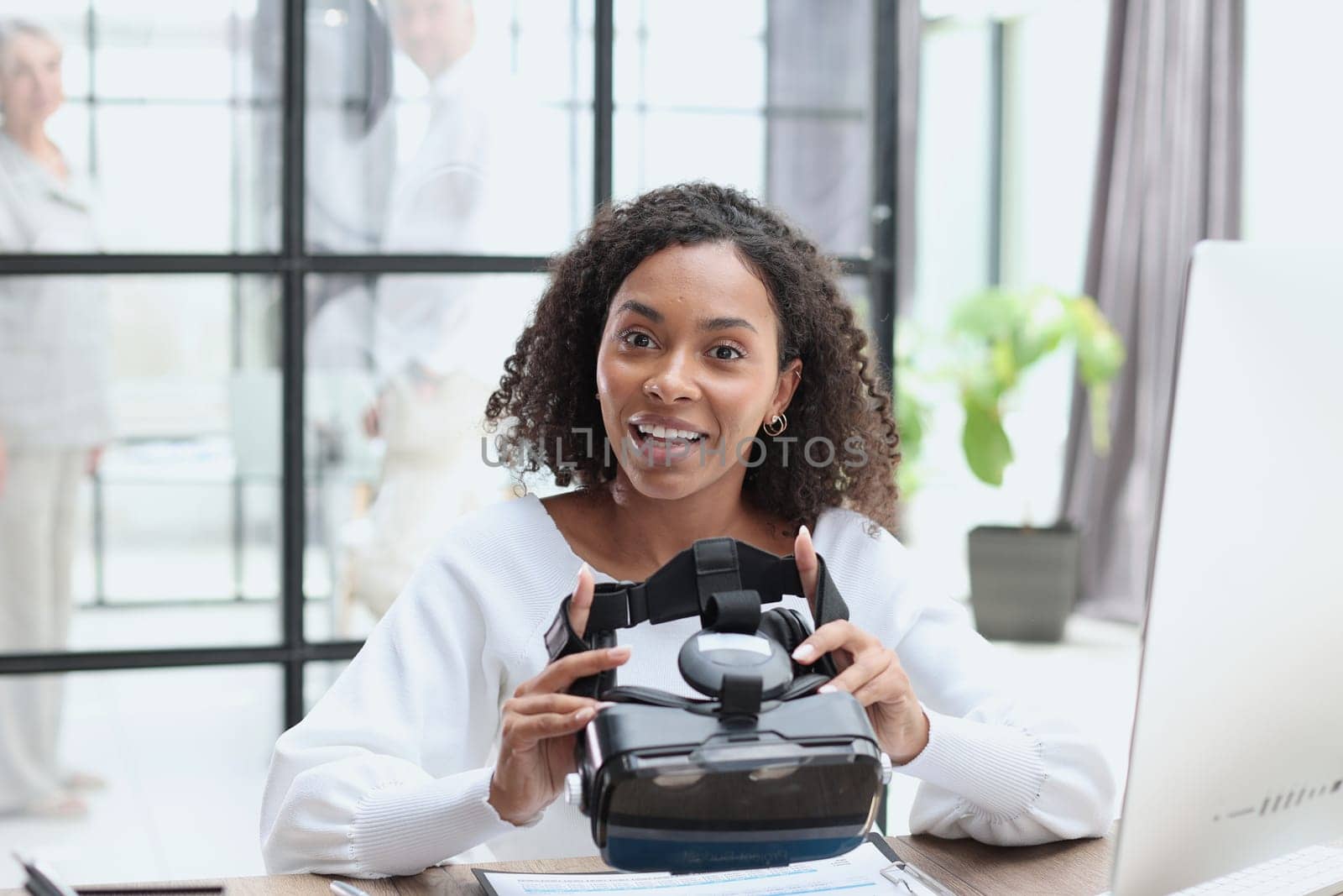 woman testing VR glasses or goggles sitting in the office room