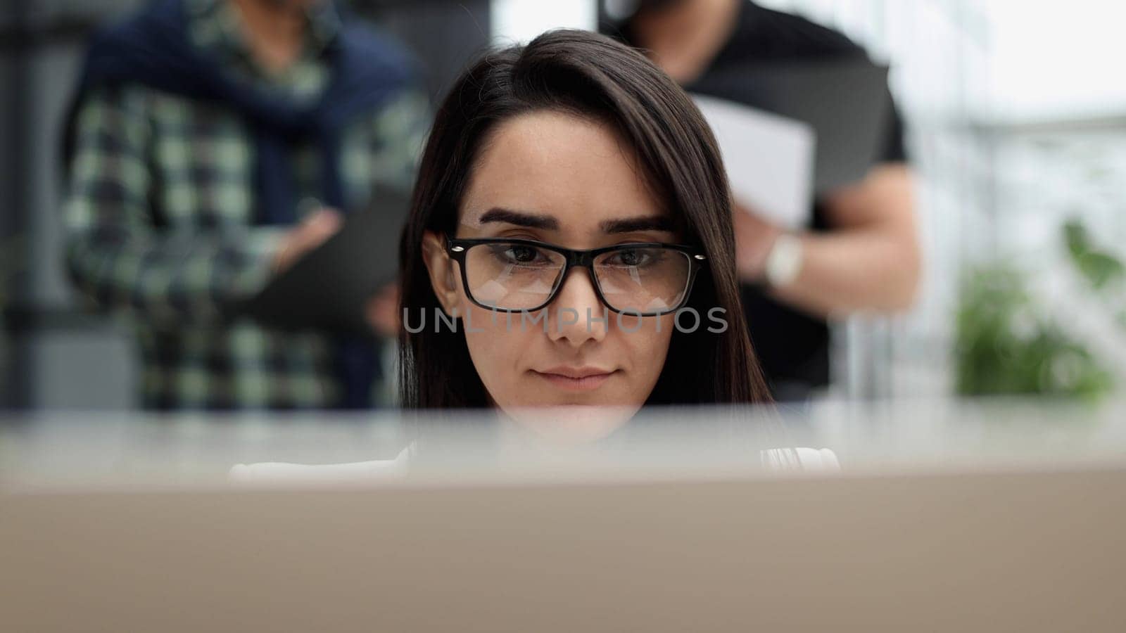 Confident business woman in casual clothes sitting in the office and working on a laptop