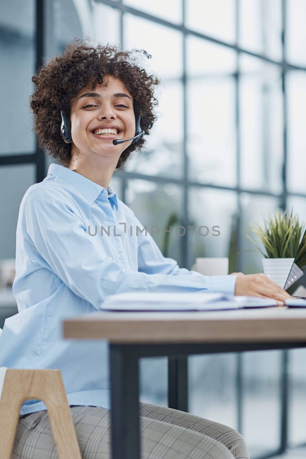 girl in a modern office working in a call center smiling.