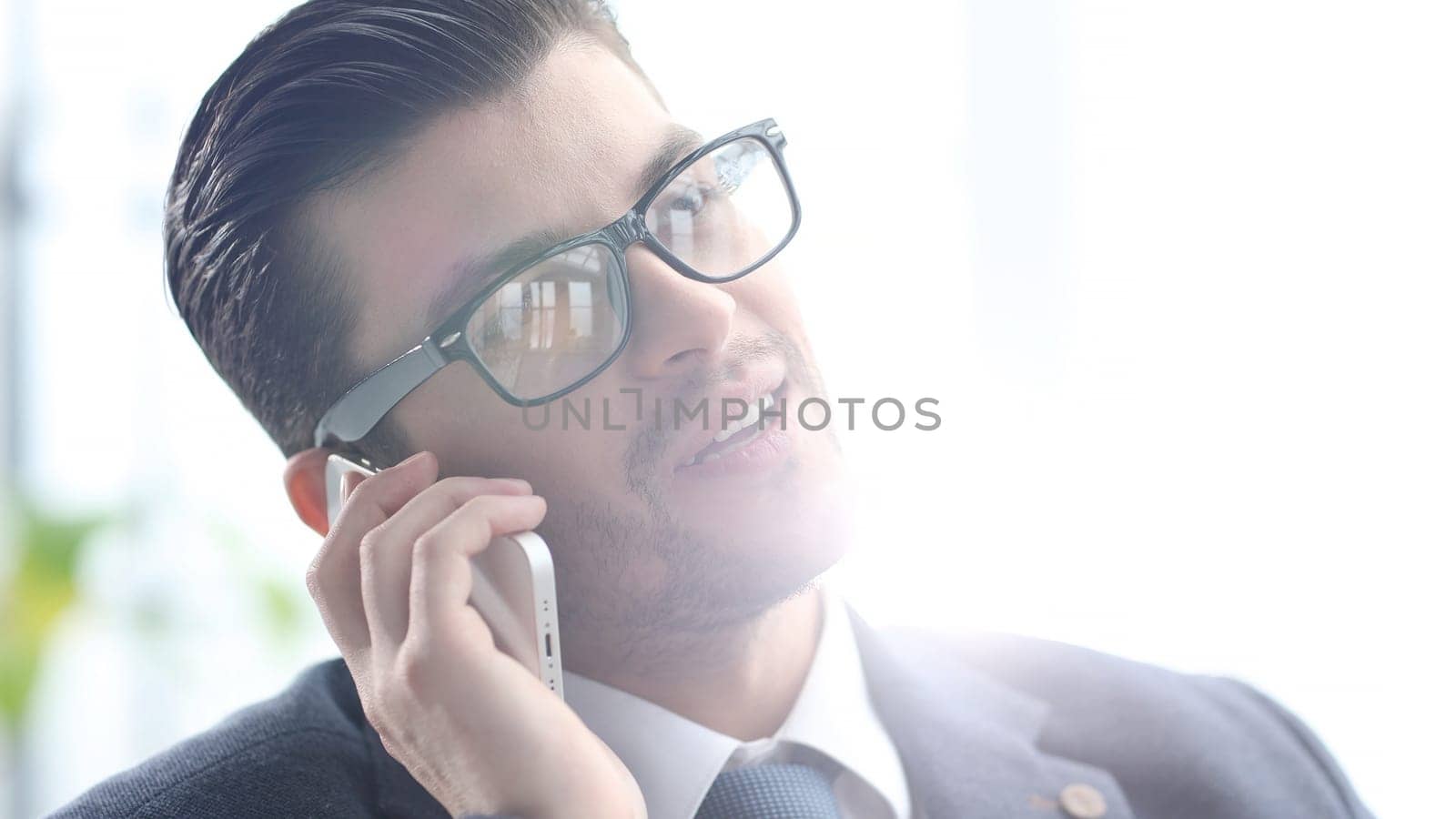 A male businessman is talking on the phone in close-up.