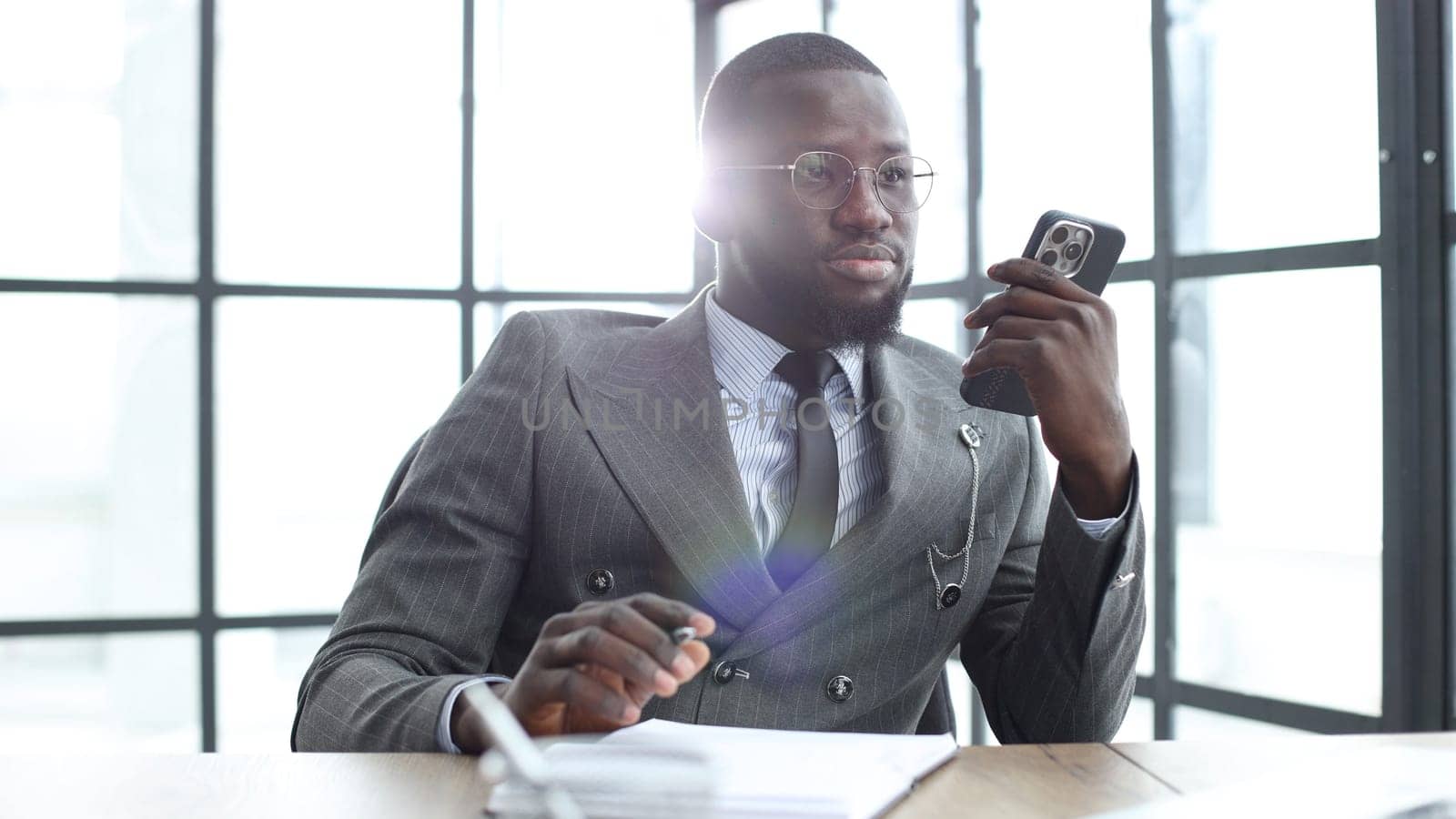 A businessman man in a close-up in a jacket, he is talking on the phone in the office.
