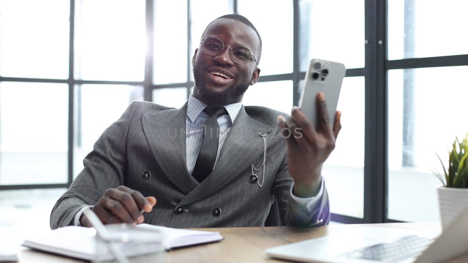 A businessman man in a close-up in a jacket, he is talking on the phone in the office.