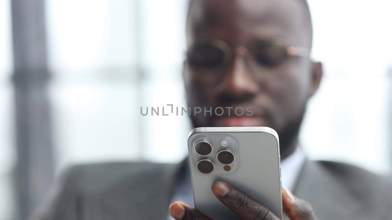 The face of a businessman man in a close-up in a jacket in the office talking on the phone.
