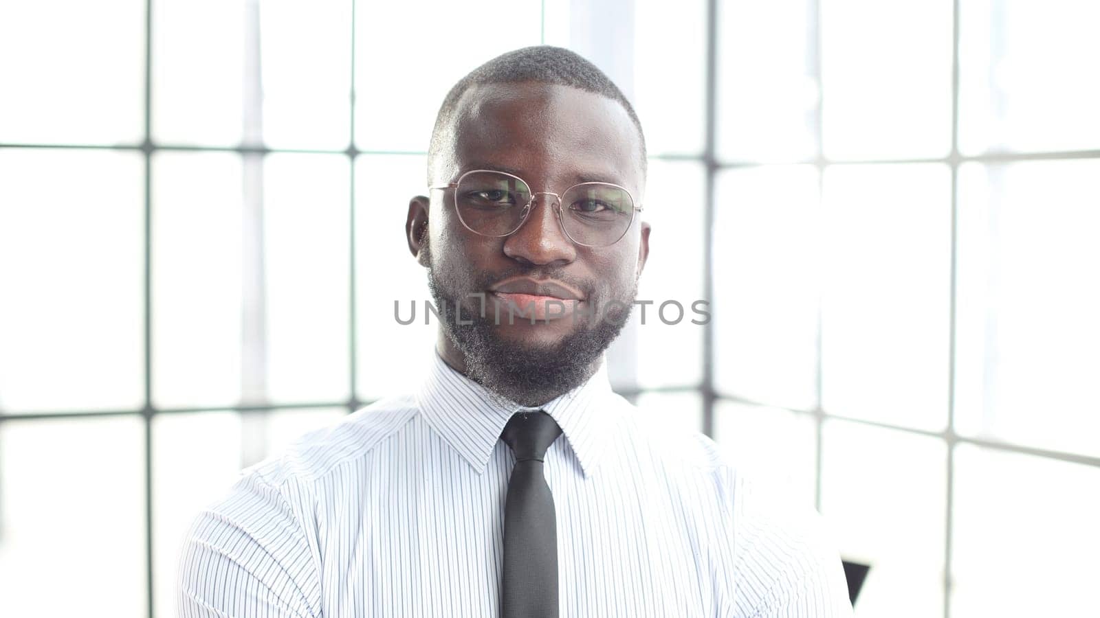 The face of a businessman man in a shirt is a close-up in the office, he looks at the camera.