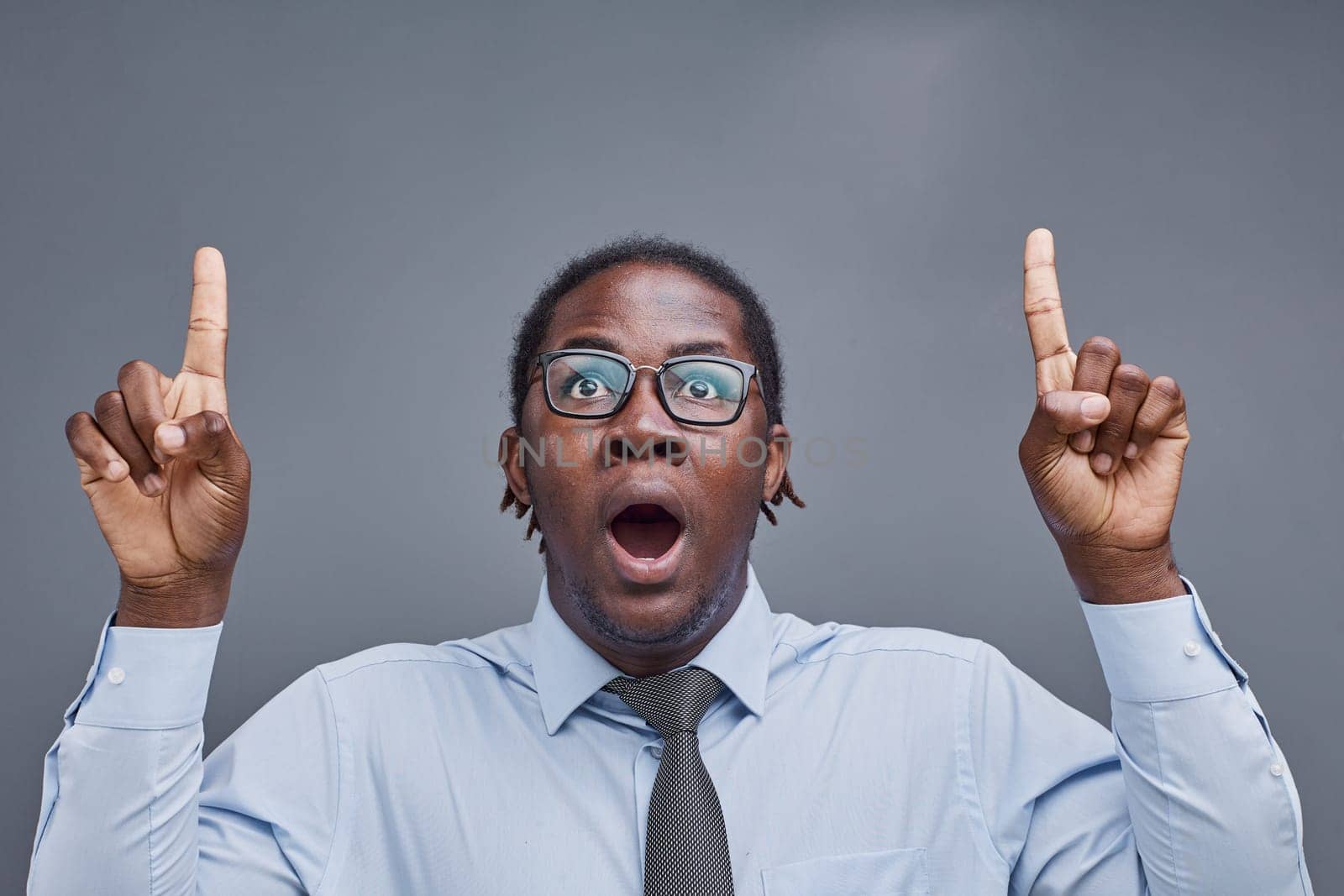 young african american man surprised showing fingers up on gray background.