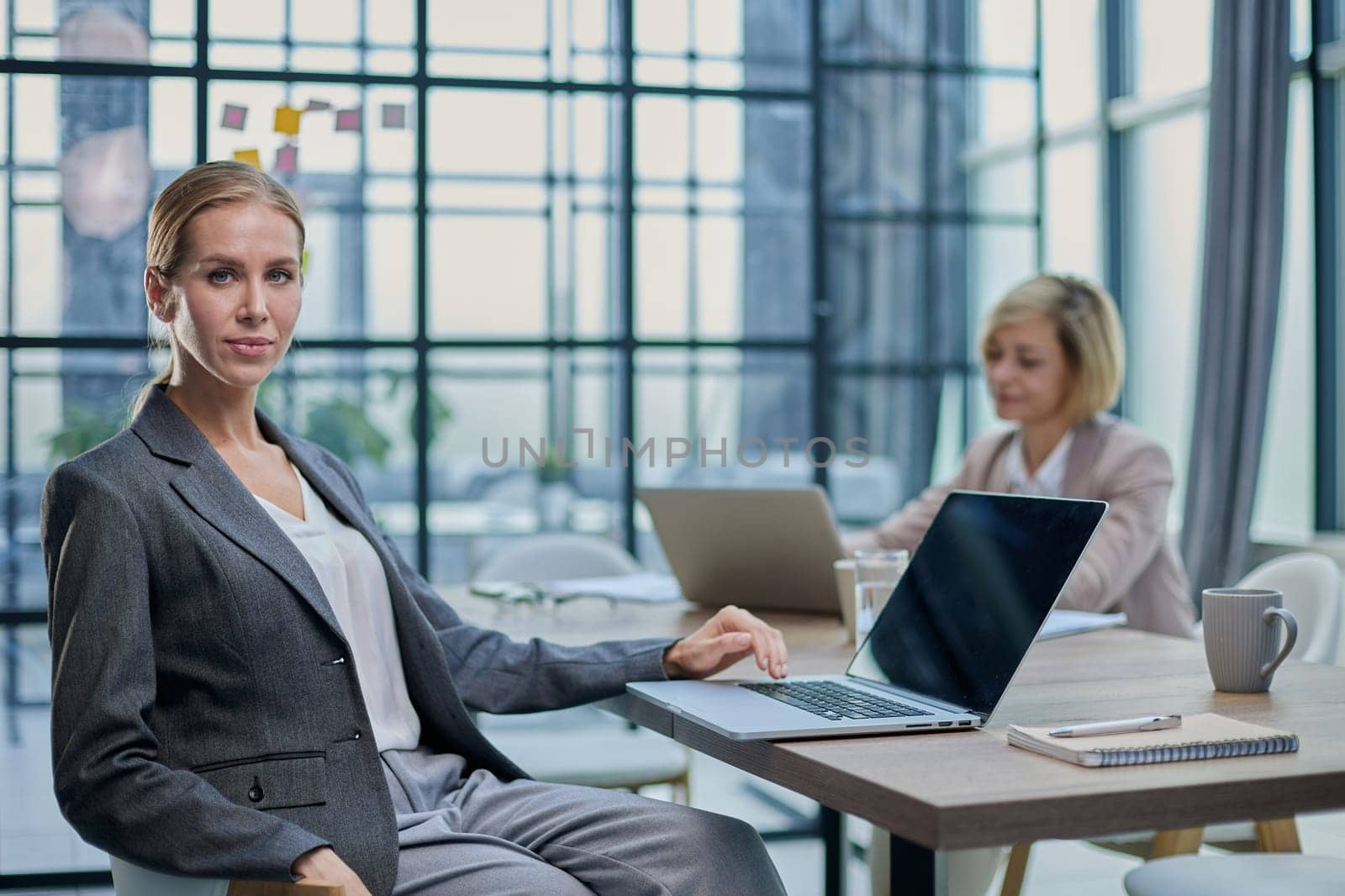 Young woman with computers at desk in office by Prosto