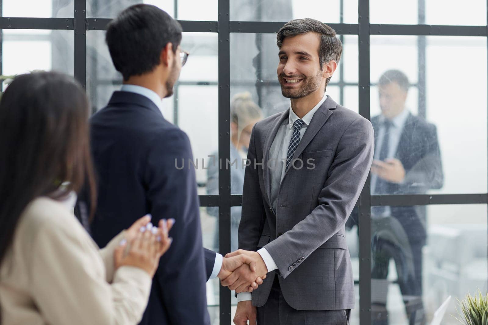 Group managers or employees standing in modern office hall after staff briefing and discussing corporate news by Prosto