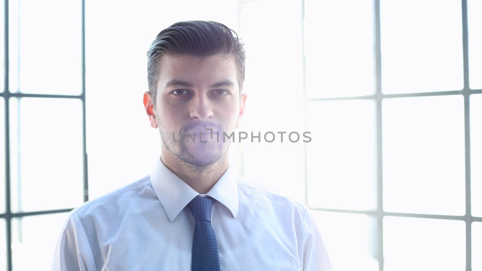 Male businessman in close-up looks at the camera.