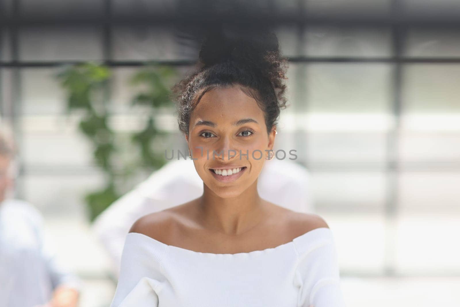 a business woman smiling inside office building by Prosto