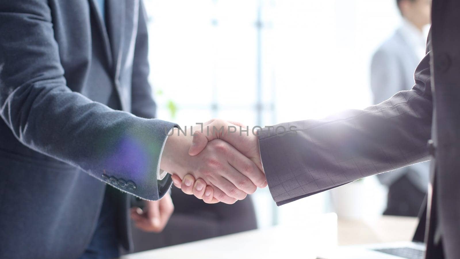 Businessmen shake hands in the office after a successful deal.