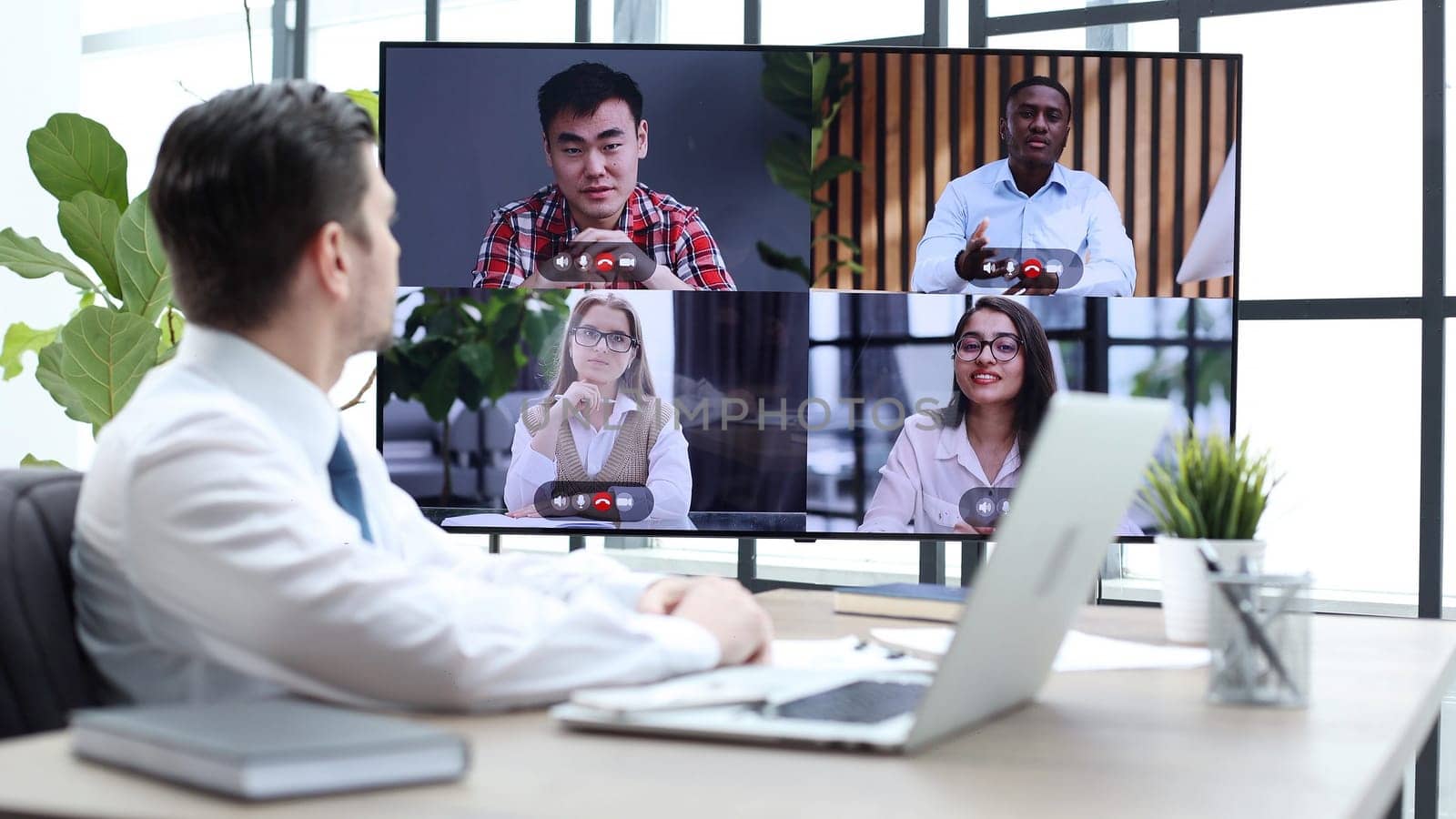 A male businessman is talking to colleagues at an online meeting.