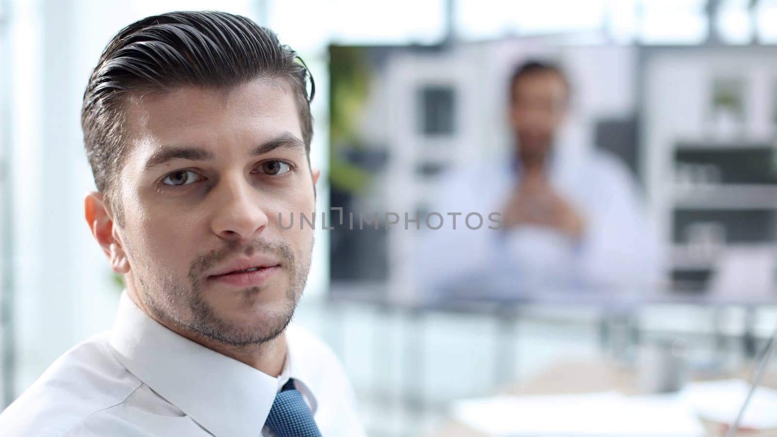 A successful office worker looks at the camera in close-up by Prosto