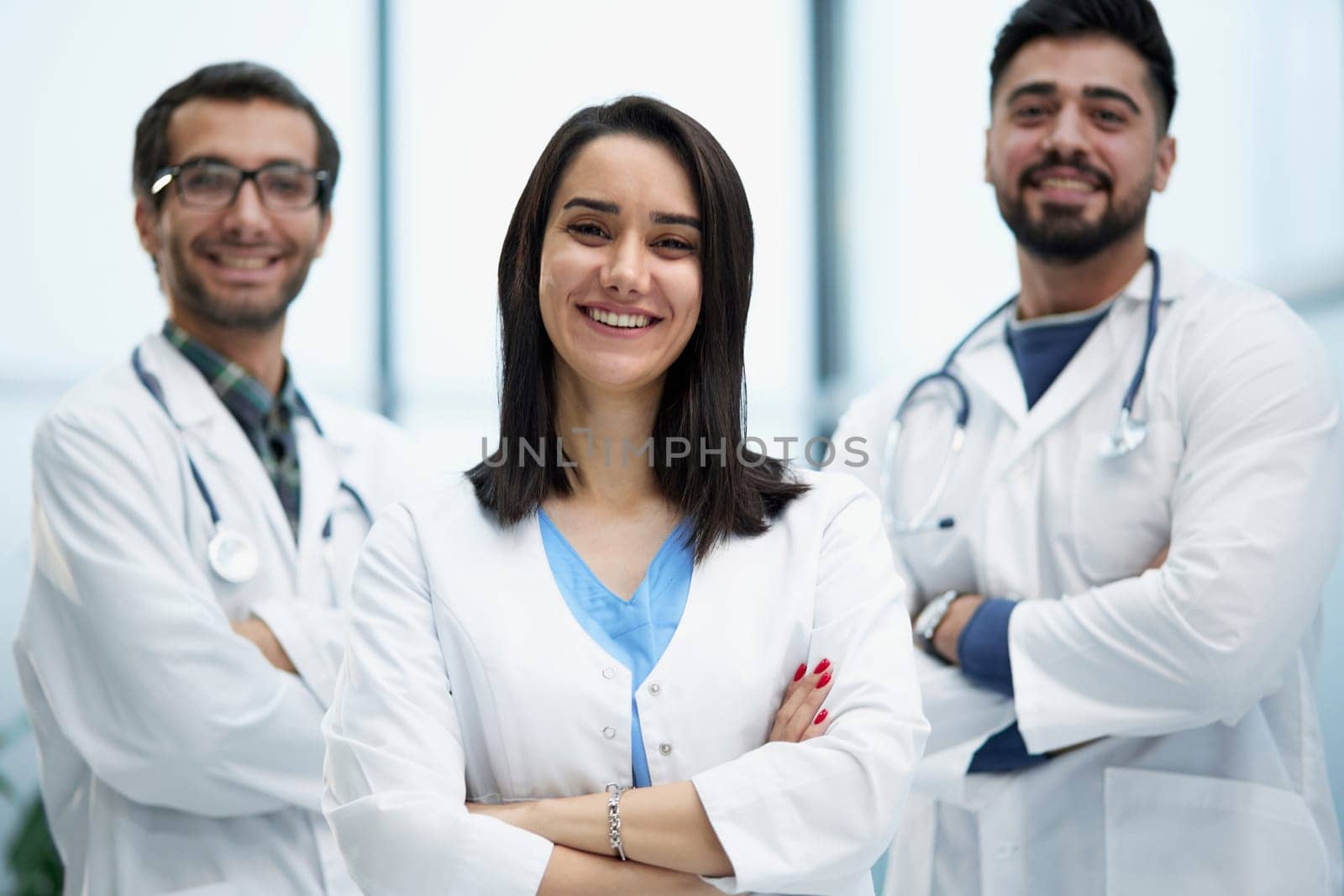 Three medical colleagues stand in the lobby of the hospital by Prosto