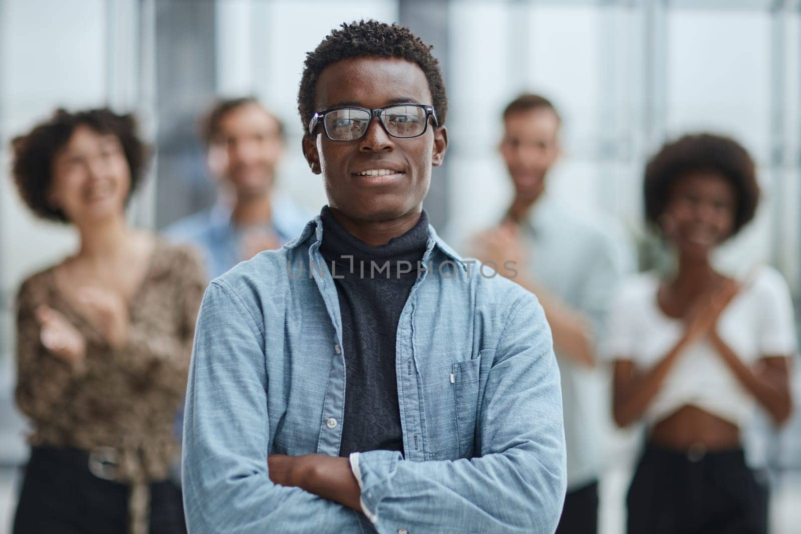 smiling African American business man with executives working in background by Prosto