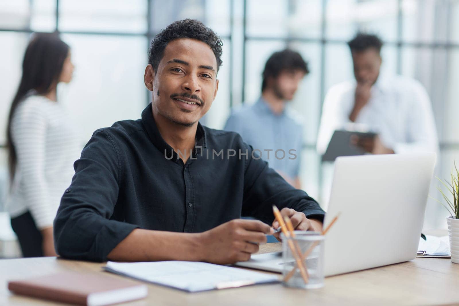 Cheerful businessman working at desk, confident and engaged.