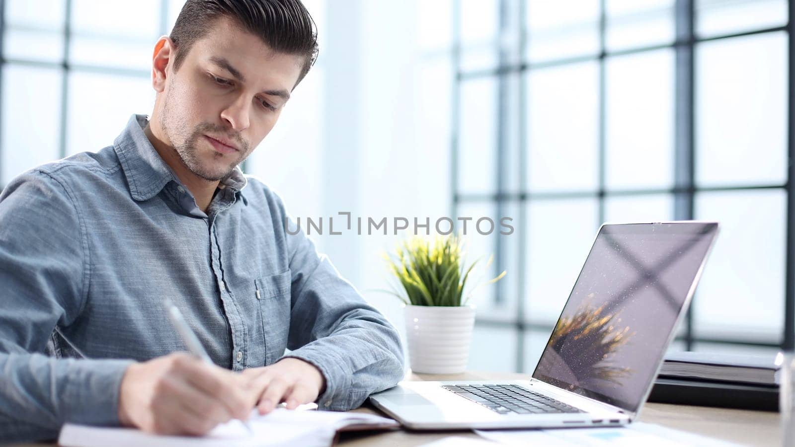 A male office worker records a report in close-up.