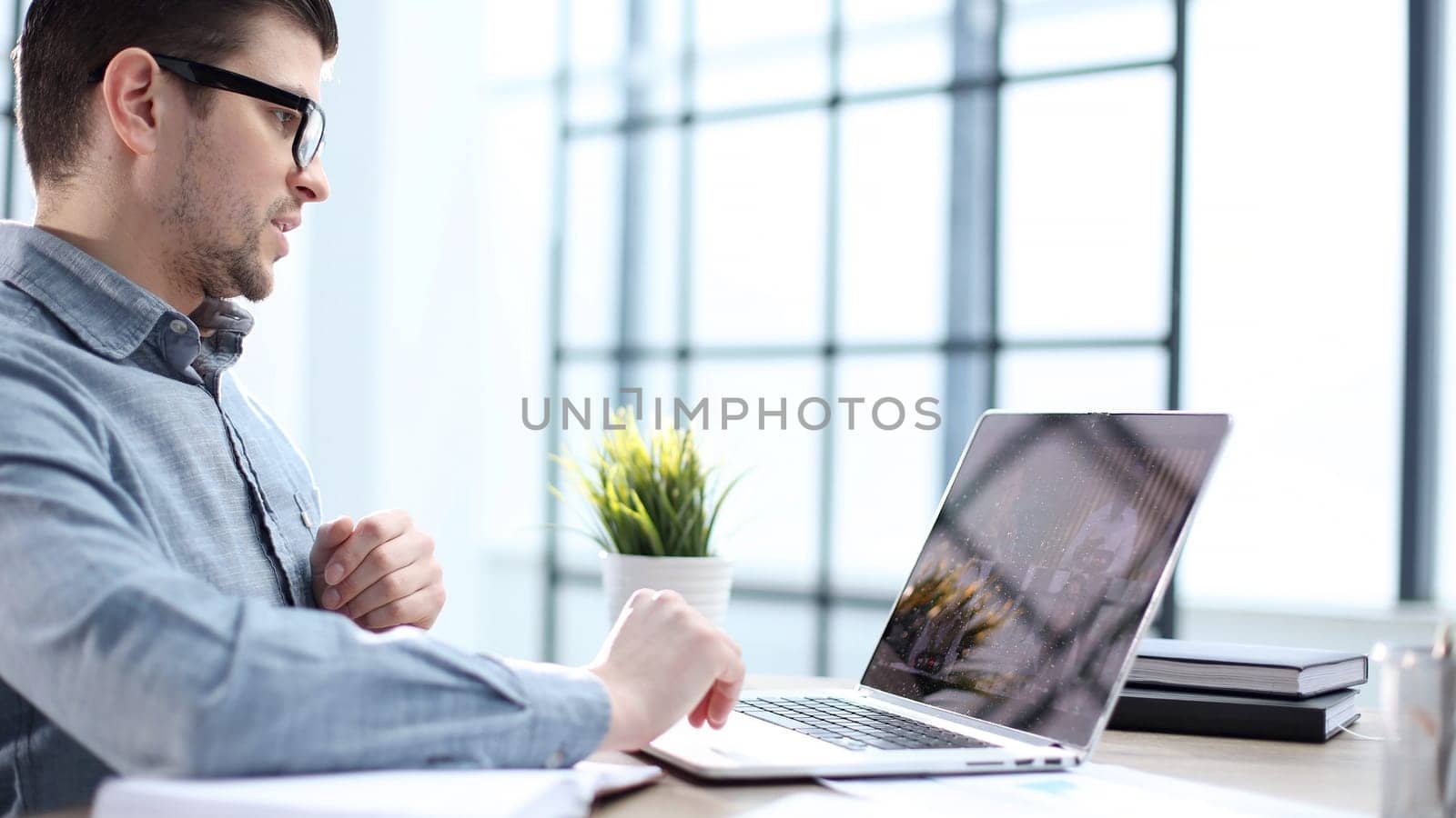 A male office worker at an online meeting with colleagues.