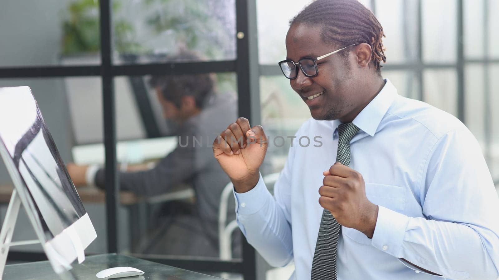 happy man working in the office. raised his hands joyfully by Prosto