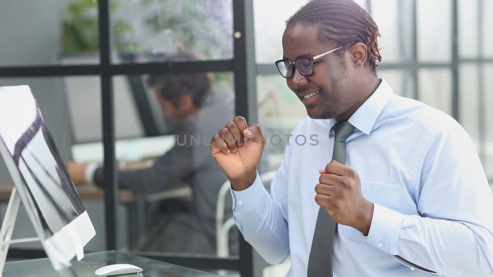 happy man working in the office. raised up his hands joyfully