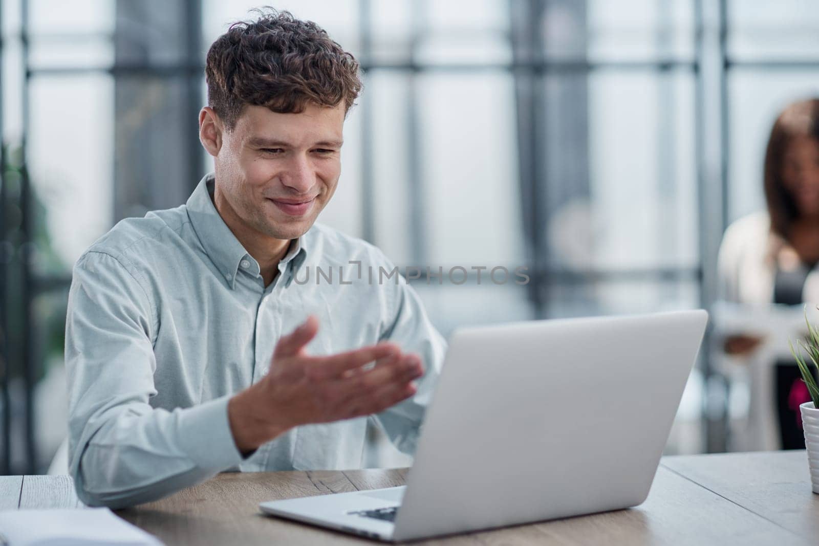 young man sitting in the office working at a laptop by Prosto