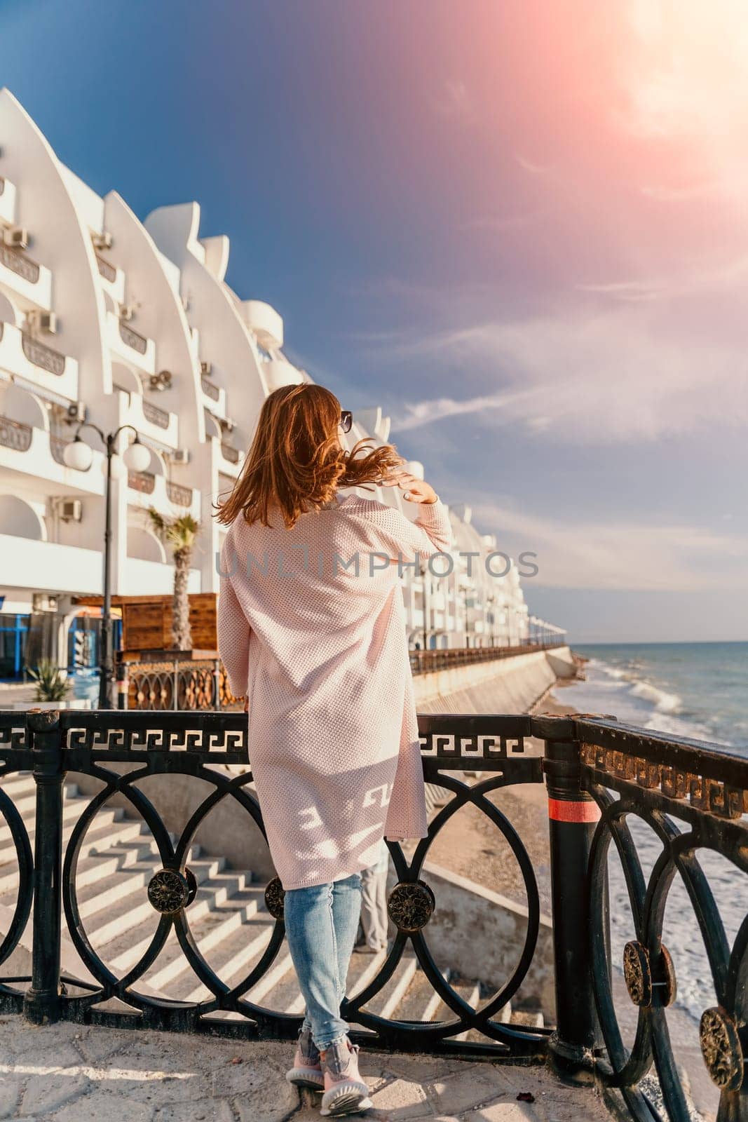 Woman summer travel sea. Happy tourist enjoy taking picture outdoors for memories. Carefree woman traveler posing on beach at sea on sunset, sharing travel adventure journey. Holiday vacation concept. by panophotograph