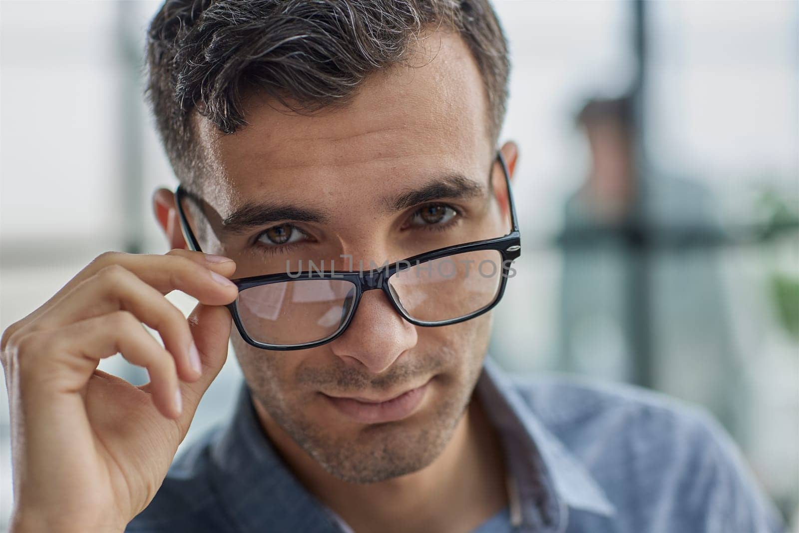 IT guy adjusting glasses in a modern new office