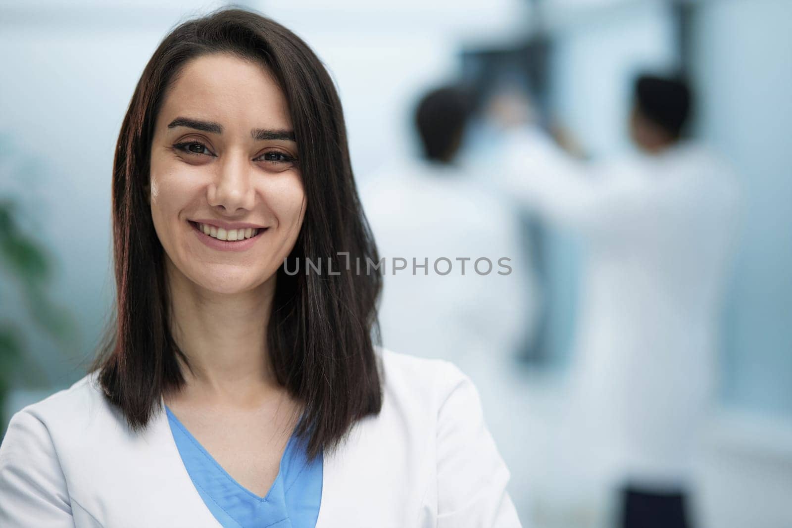 Image of confident female doctor, intern with medical robe, looking confident at camera by Prosto