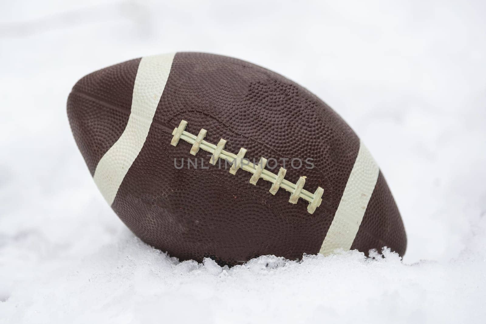 a football covered with snow and laying in the snow by Andelov13
