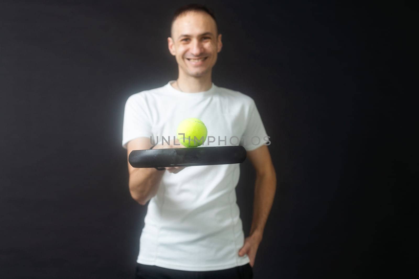 Man ready for paddle tennis serve in studio shot. High quality photo