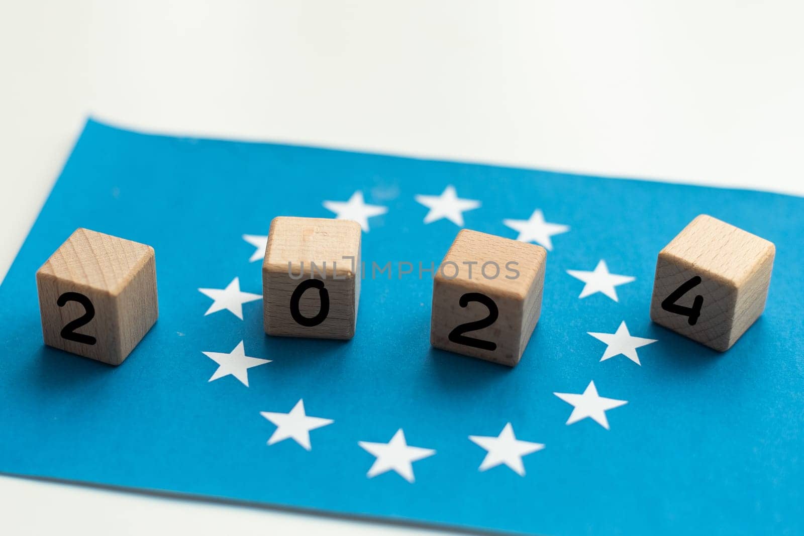 European Union vote, 2024 on wooden blocks against the background of the EU flag, the concept of voting and taking part in the European elections. High quality photo