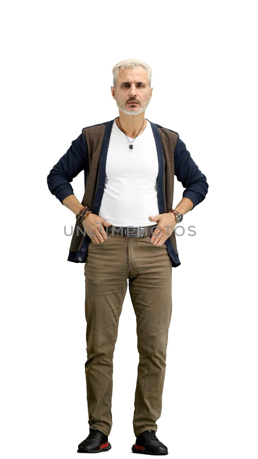 A man, full-length, on a white background, hands on hips.