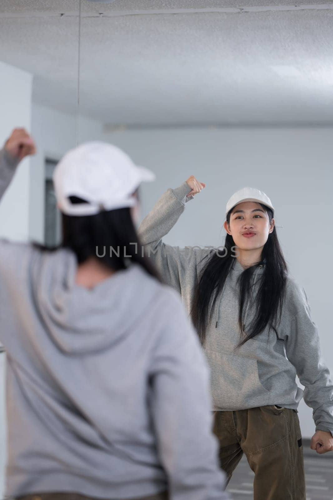 Shot of active young woman practicing break dancing in spacious dance studio.