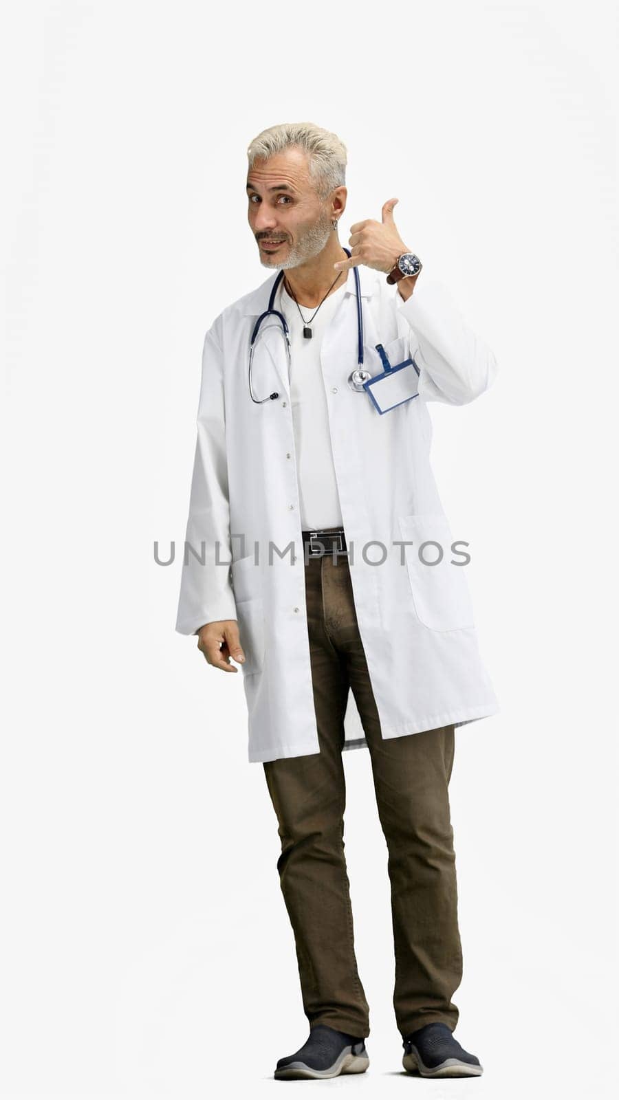 The doctor, in full height, on a white background, shows a call sign.