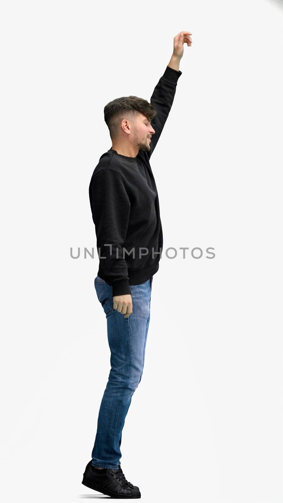 A man, full-length, on a white background, jumps.