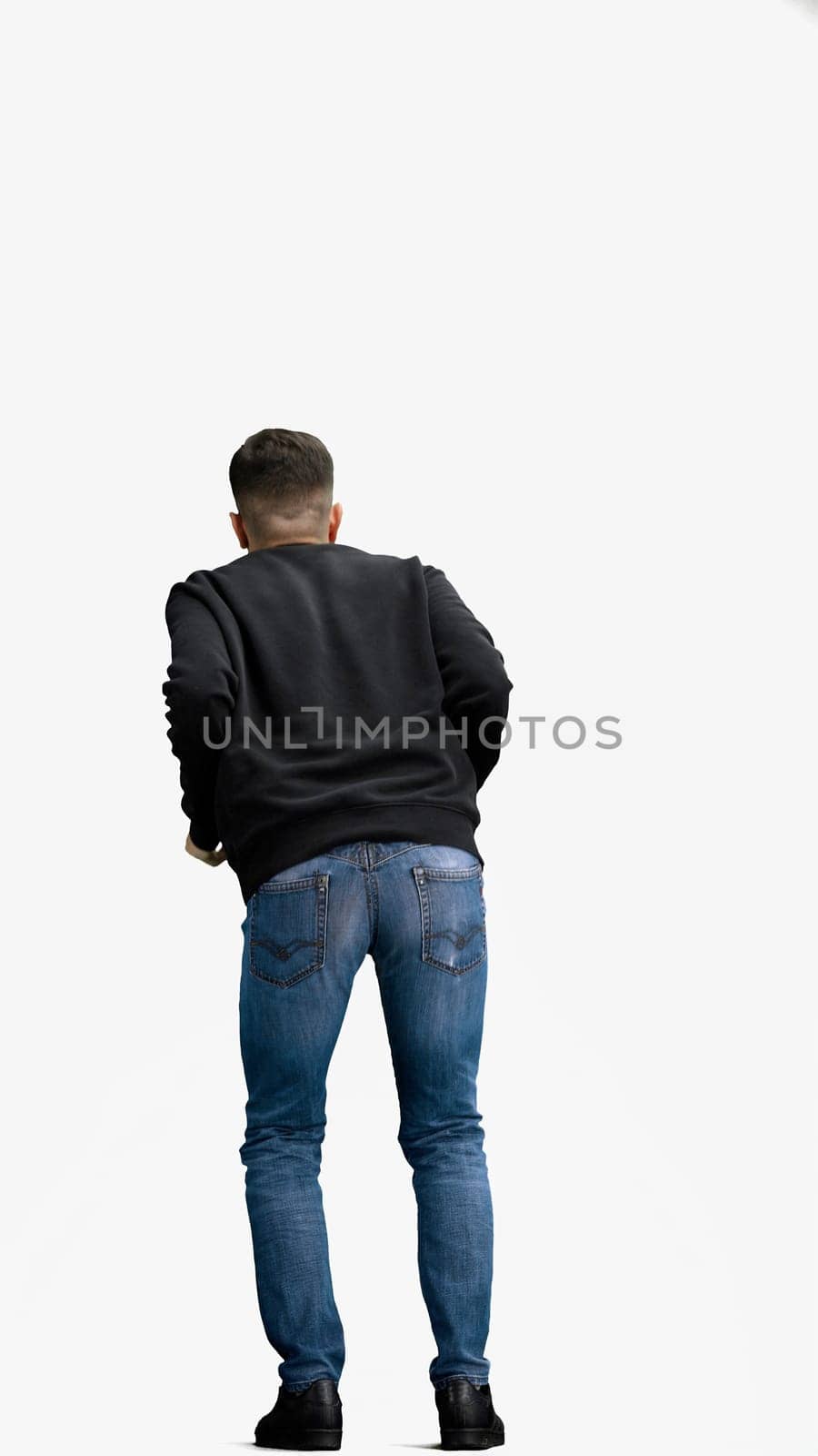 A man, full-length, on a white background, rubs his hands.