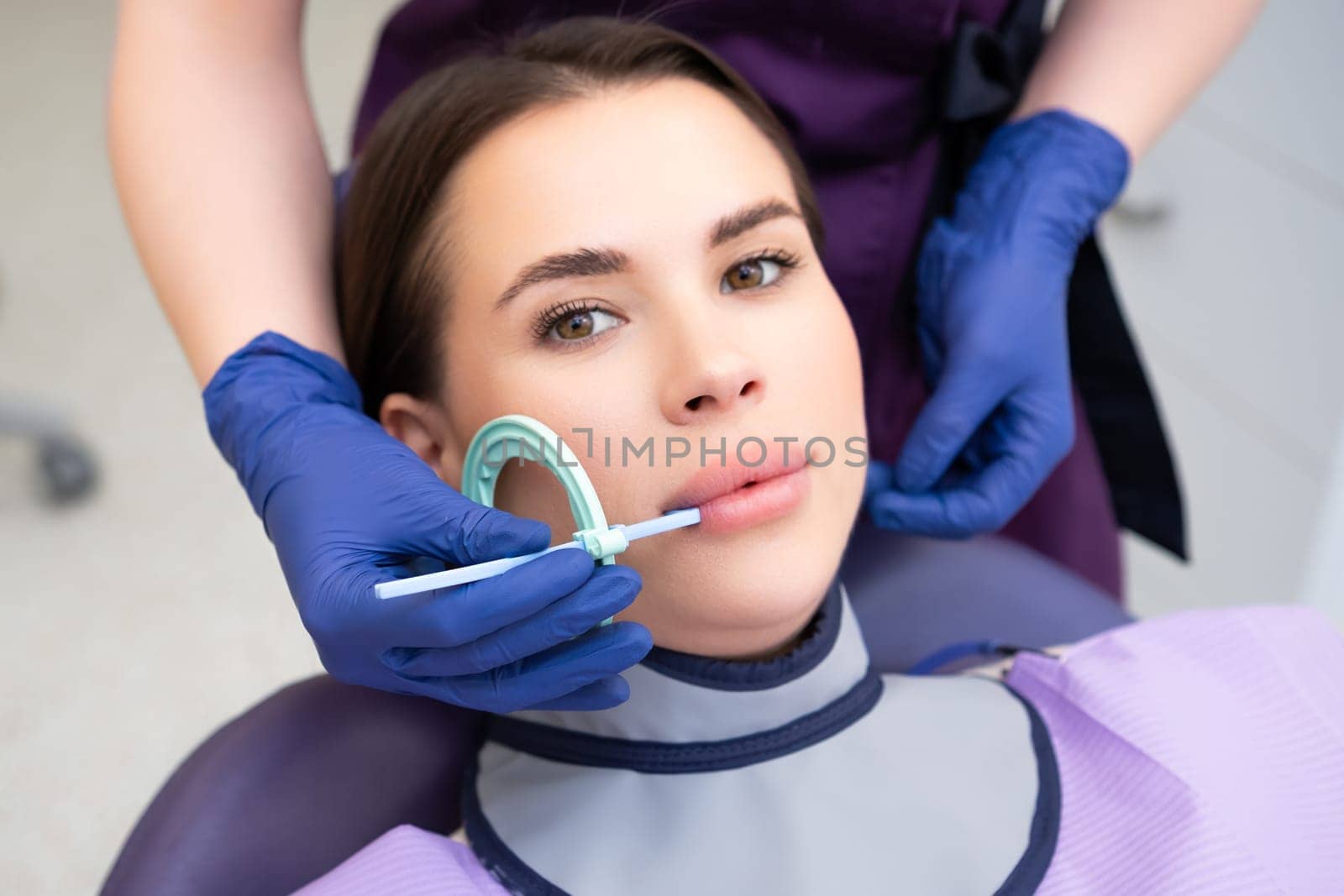 Process of preparation of patient before dental X-ray procedure. Woman instructs patient on how to tilt head before dental X-ray procedure