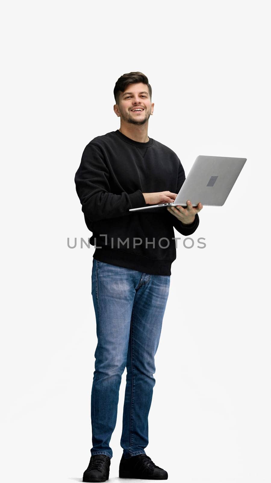 A man, full-length, on a white background, uses a phone.