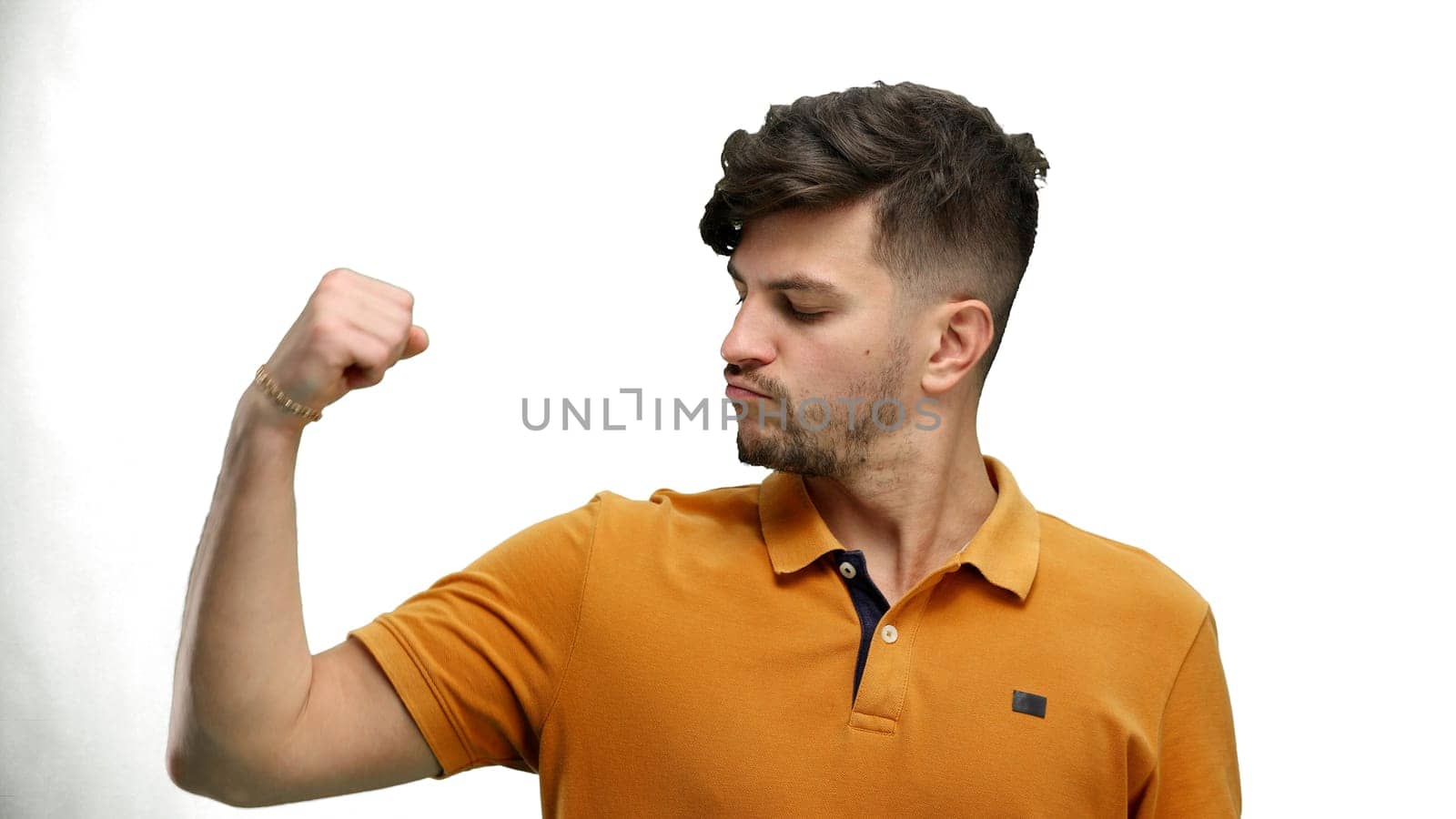 Man, close-up, on a white background, shows strength.