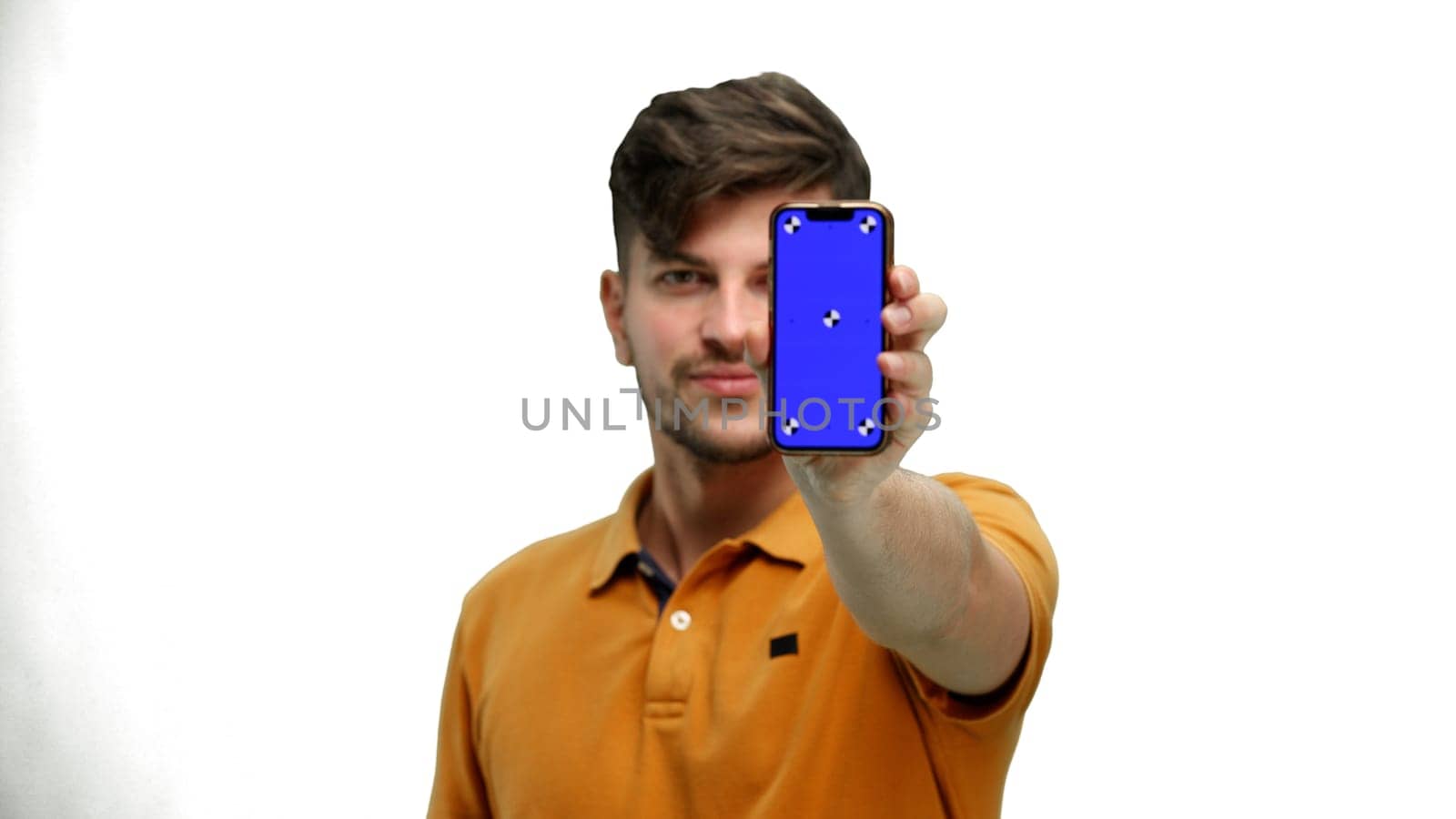 A man, close-up, on a white background, shows a phone.