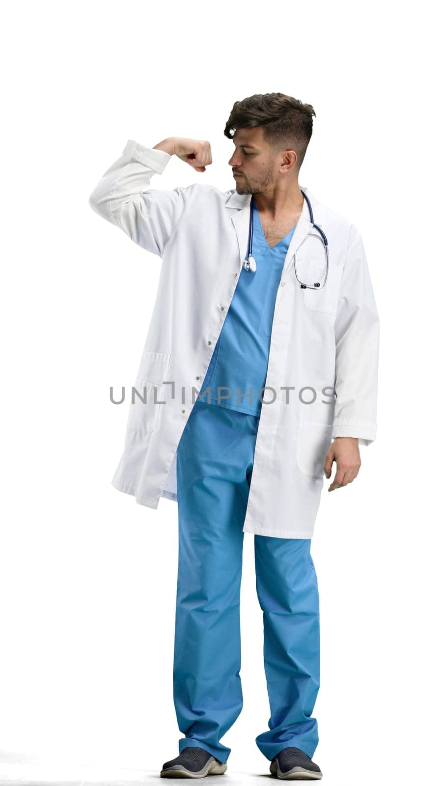 The doctor, in full height, on a white background, shows strength.